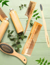 Wooden neem comb placed in natural, earthy setting with styling tools