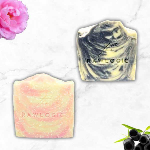 Two soap bars with 'RAWLOGIC' branding on a marble surface with a pink flower and blackberries.