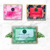 Three soap packaging boxes with floral designs and product names on a white background.