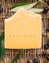Bar of soap with 'the RAWLOGIC' branding on a woven background with leaves and olives.
