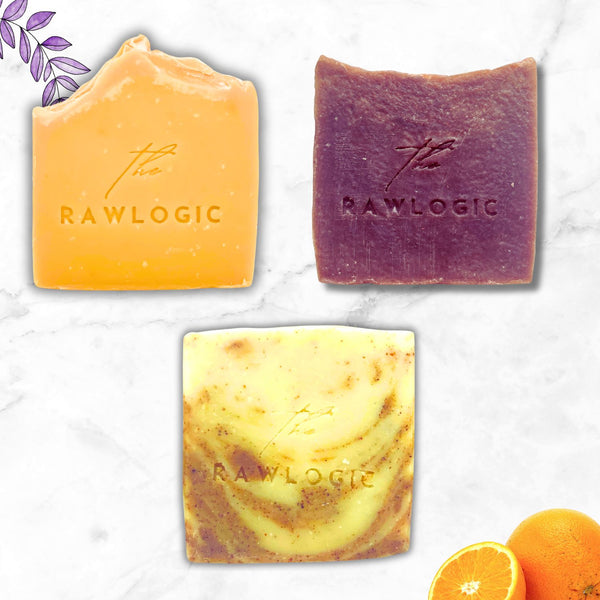 Three different colored soap bars with 'Rawlogic'on a marble surface.